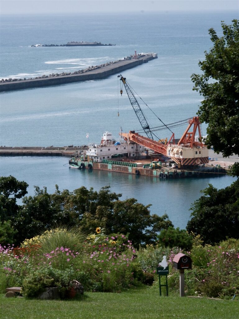 浦河港の起重機船と防波堤、手前の花壇